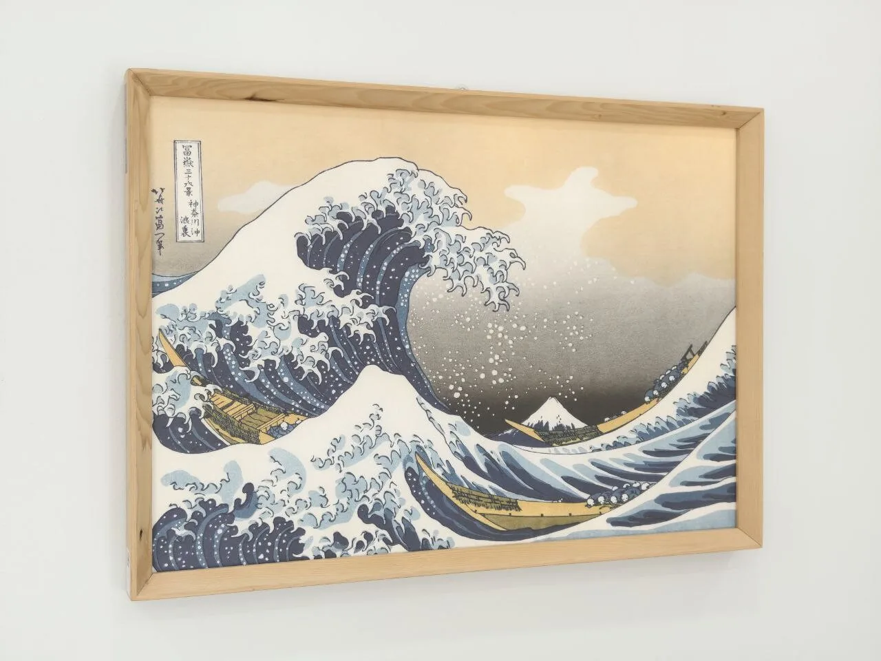 A framed print of Hokusai's Great Wave hanging in a GO Laundry branch